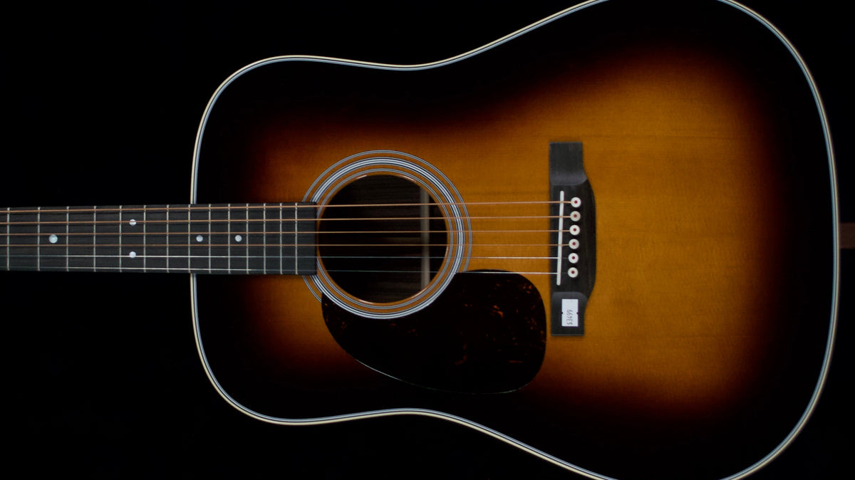 Sunburst Martin D-28 left-handed acoustic guitar with a dark pickguard against a black background