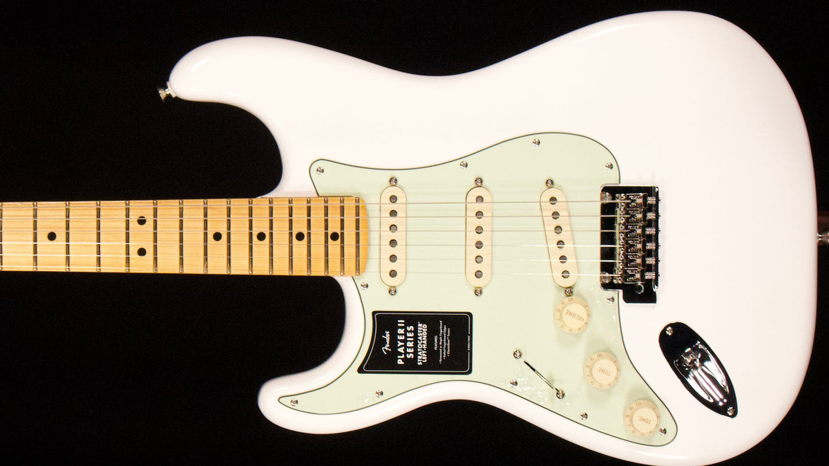 White Fender Player II left-handed Stratocaster with a maple fretboard against a black background