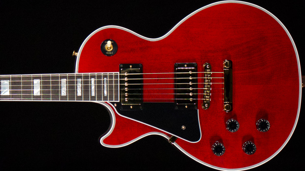 Red left-handed Gibson Les Paul Custom body with gold-colored hardware, two covered pickups, black pickguard, and contrasting binding.