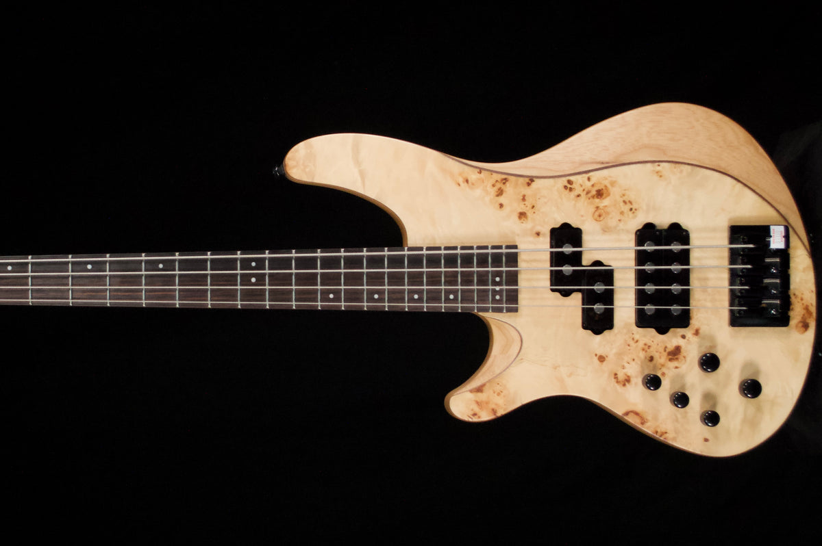 Burnt orange electric bass guitar on a black background