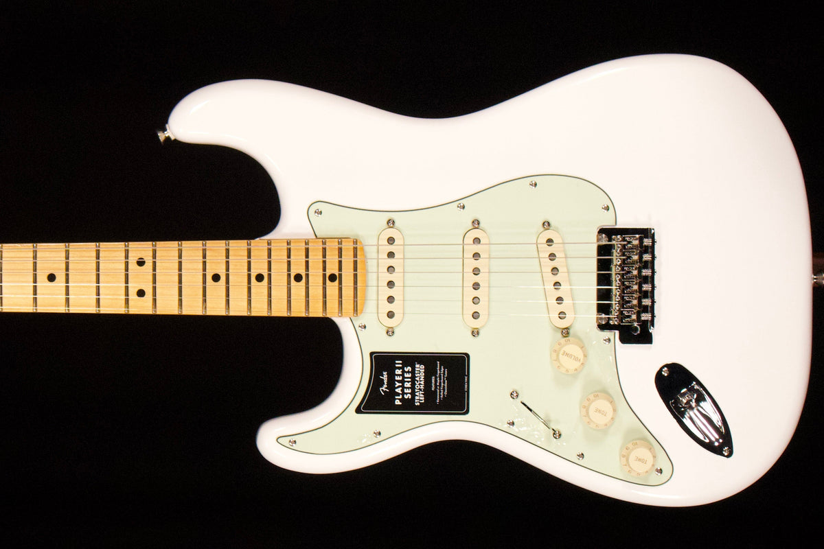 White Fender Player II left-handed Stratocaster with a maple fretboard against a black background