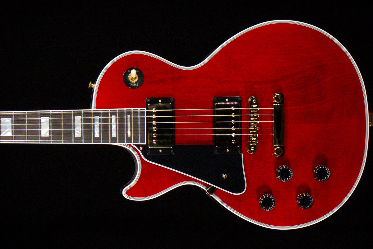 Red left-handed Gibson Les Paul Custom body with gold-colored hardware, two covered pickups, black pickguard, and contrasting binding.