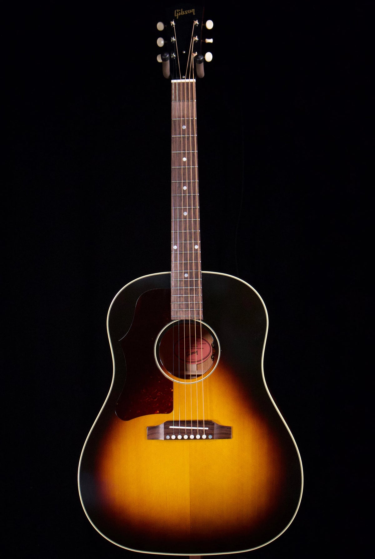 Vintage sunburst left-handed acoustic guitar against a dark background